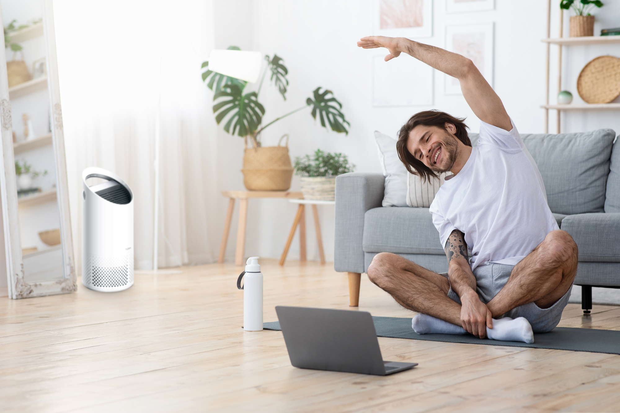 Man stretching on the floor, TruSens Air Purifier in the background.