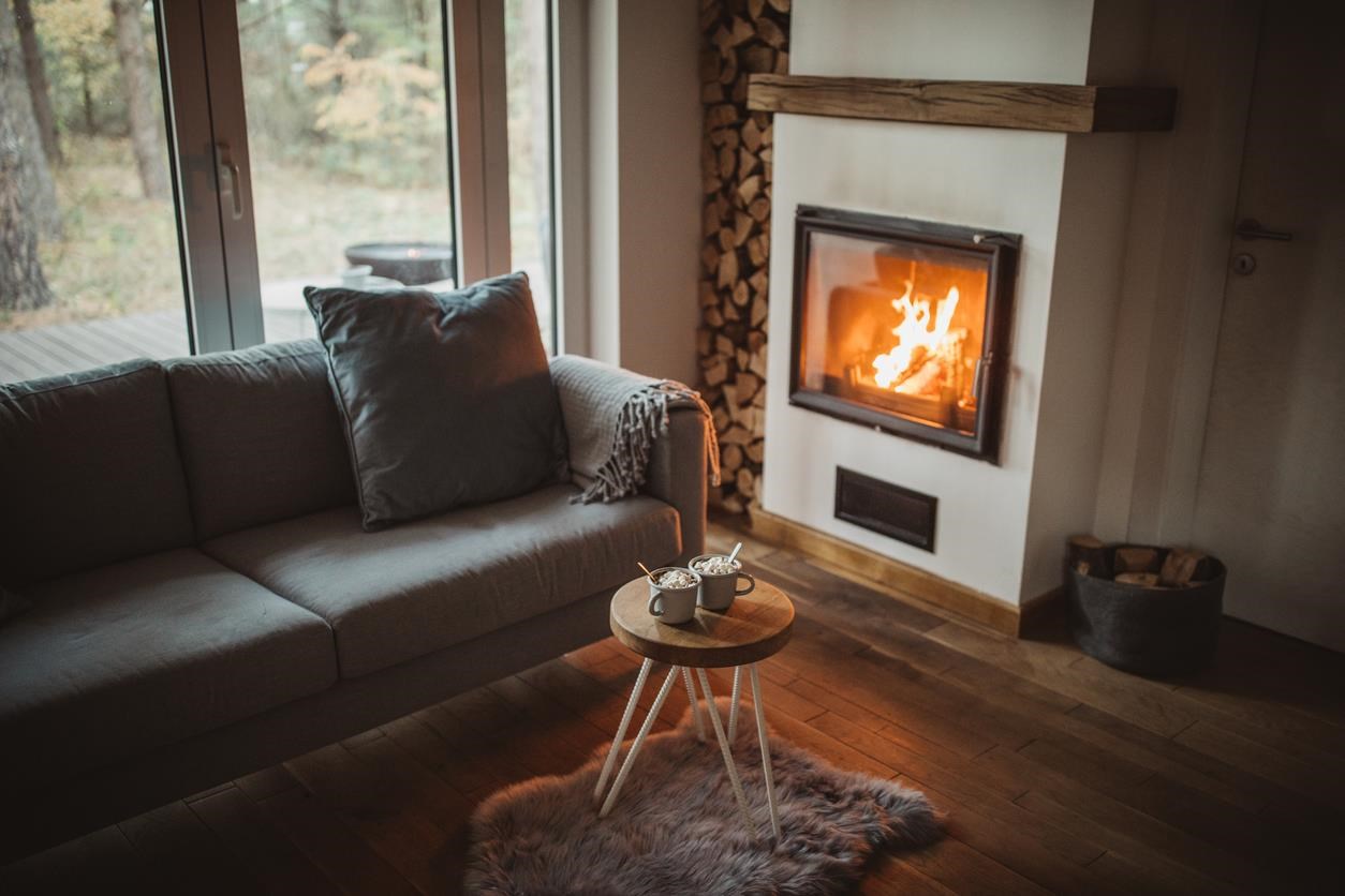 Cozy room with fire in fireplace and hot chocolate on table. 