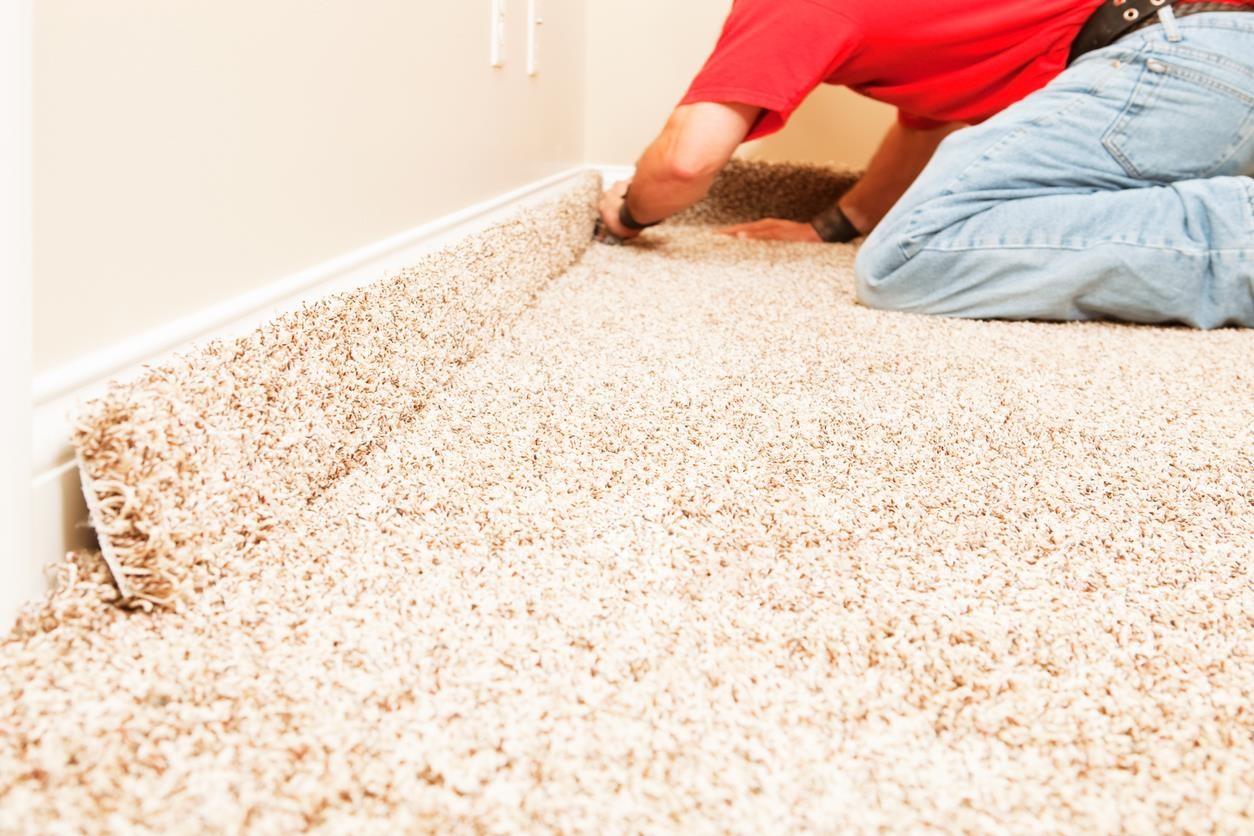 A man installing carpet flooring. 
