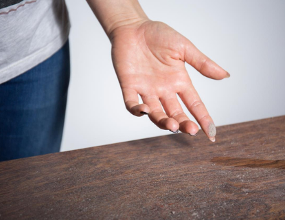 Finger swiping dust off table.