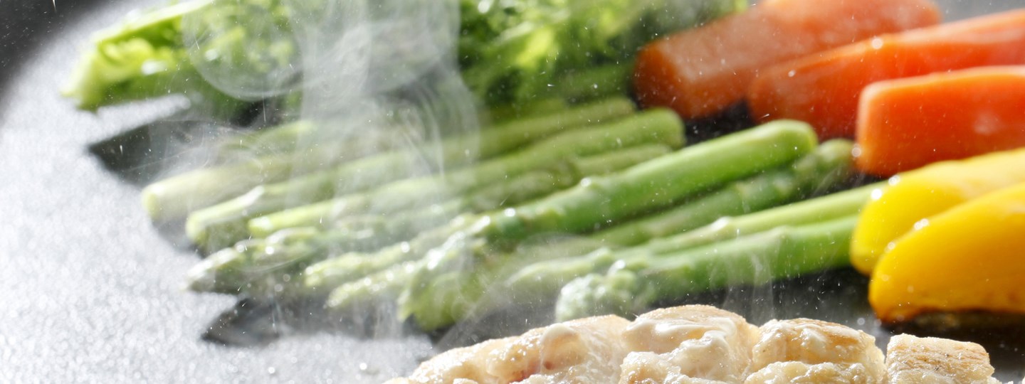 Vegetables cooking on a flat top. 