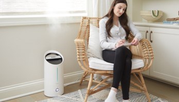 Woman sitting next to TruSens humidifier