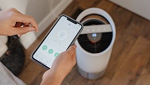 TruSens Air Purifier in the background with TruSens Smart app open on a smart phone